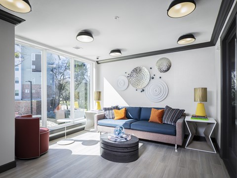 A modern living room with a blue sofa and a yellow side table.