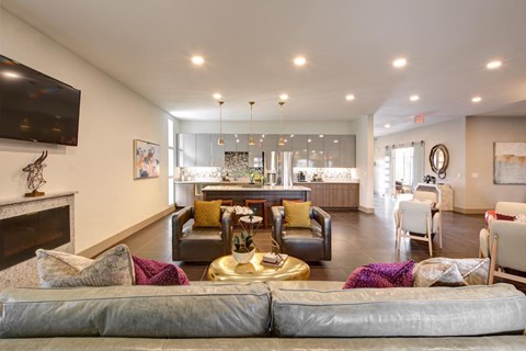 A living room with a grey sofa and a fireplace.