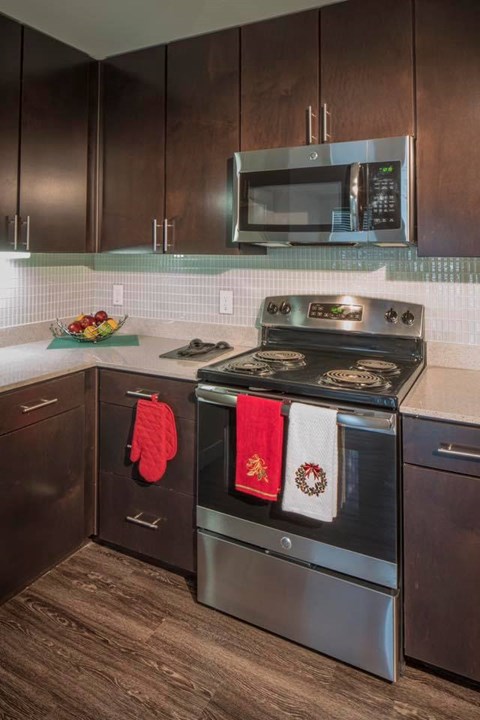 A modern kitchen with a stove top oven and microwave above it.