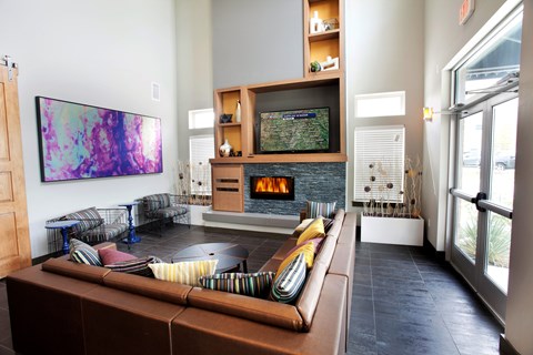 A living room with a brown couch and a TV on a stand.