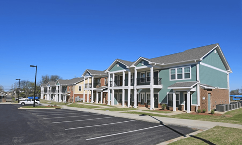 A large building with a parking lot in front.
