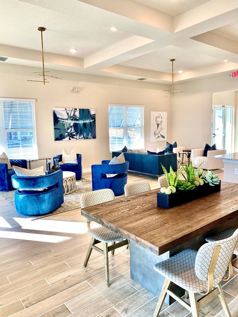 A modern living room with a wooden table and blue chairs.