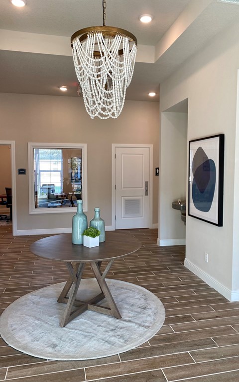 A modern dining room with a round table and a chandelier.