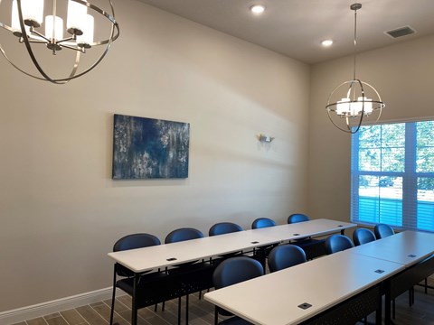 A conference room with a long table and chairs.