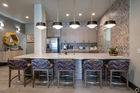 A kitchen with a white counter top and bar stools.