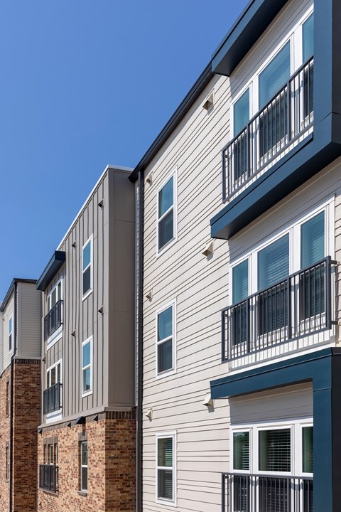 A modern apartment building with balconies and windows.