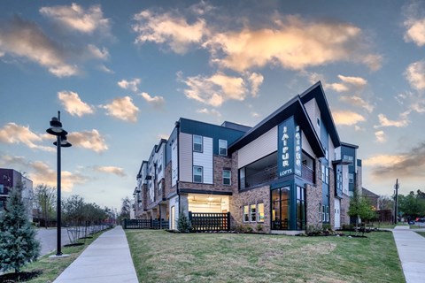 A modern apartment building with a well-maintained lawn in front.