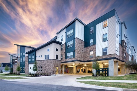 A modern apartment building with a mix of green and beige exterior colors.