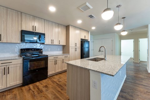 A kitchen with wooden cabinets and a granite countertop.
