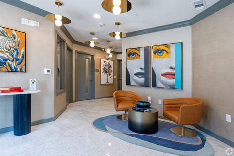 A hallway with a blue carpet and a painting of a woman's face on the wall.