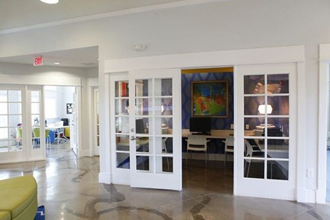 A room with a yellow sofa and a painting on the wall.