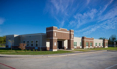 A large building with a parking lot in front.