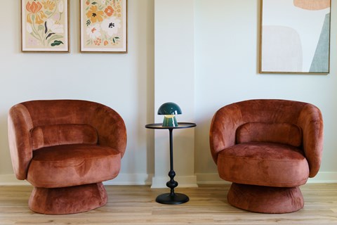 Two brown chairs and a table in a room.