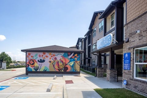 A building with a mural on the side and a sign that says "Blue Plate".