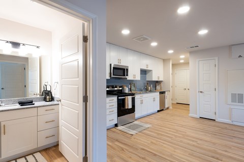 A kitchen with white cabinets and a wooden floor.