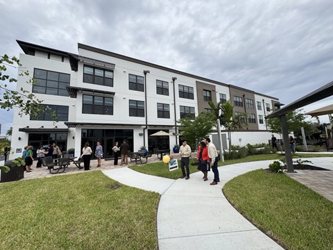 A group of people are standing outside a modern building.