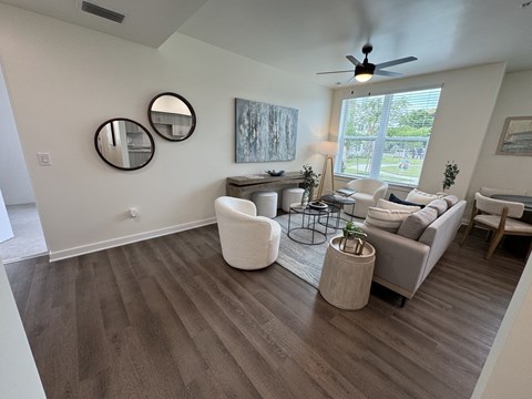 A living room with a ceiling fan and a large window.