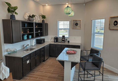 A kitchen with a table and chairs in the middle.