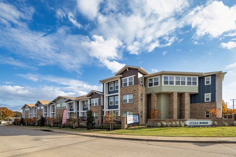 A large multi-story building with a sign that reads "LivWell Ridge" in front of it.
