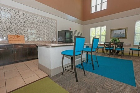 A kitchen with a blue chair and a blue rug.