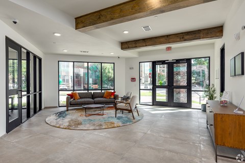 A spacious living room with a couch, coffee table, and a rug.