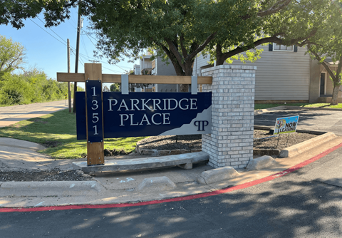 A sign for Parkridge Place is displayed in front of a building.
