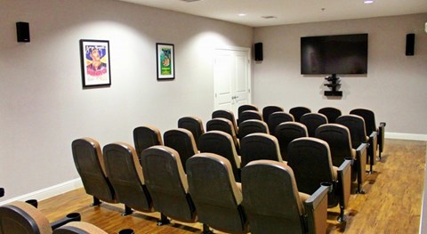 A room with a row of chairs and a television mounted on the wall.