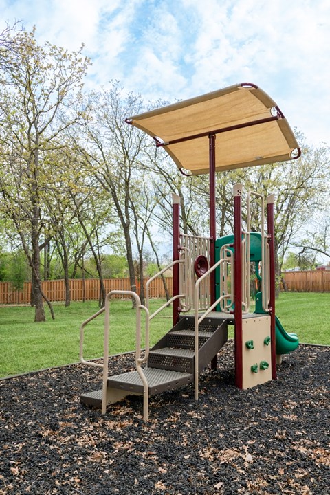 A playground with a slide and a canopy.