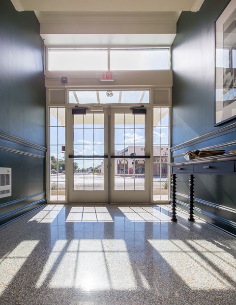 A hallway with a white exit sign above the door.
