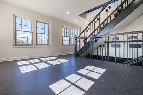 A spacious room with a staircase and large windows.