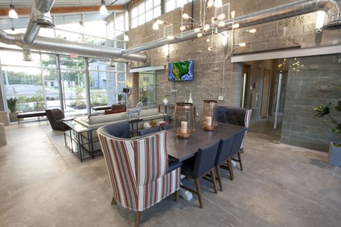 A modern dining room with a long table and striped chairs.