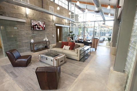 A living room with a brown leather chair and a white couch.