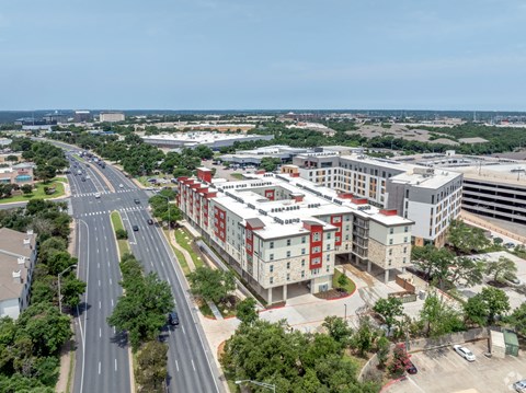 A road with cars and a building with red and white stripes.