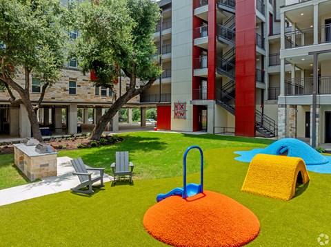 A playground area with a slide, swings, and a ball pit.