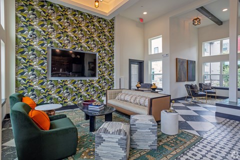 A living room with a green armchair and a patterned wallpaper.