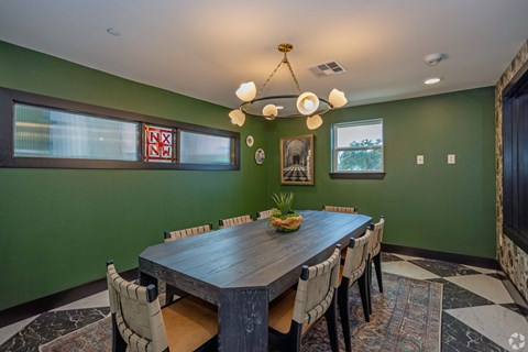 A dining room with a wooden table and chairs.