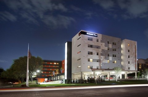 A building with a dark sky in the background and a flag on a pole in front of it.