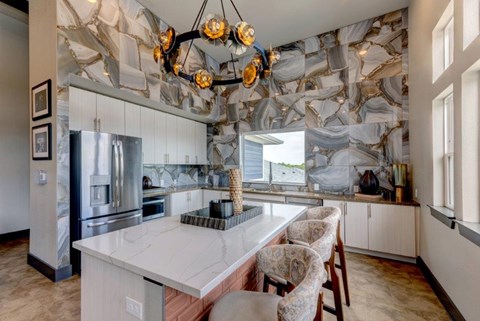 A kitchen with a marble backsplash and a large island.