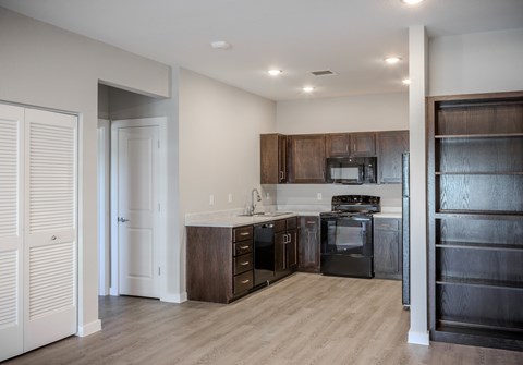A modern kitchen with dark wood cabinets and stainless steel appliances.