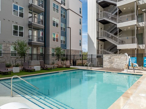 A swimming pool in front of apartment buildings.