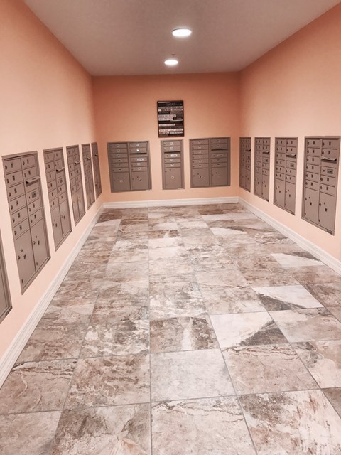 A room with a marble floor and a wall of lockers.