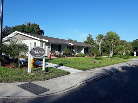 A sign for Villages at Peterson Park is on the corner of a street.