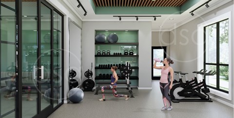 A woman is drinking water in a gym with a variety of equipment.