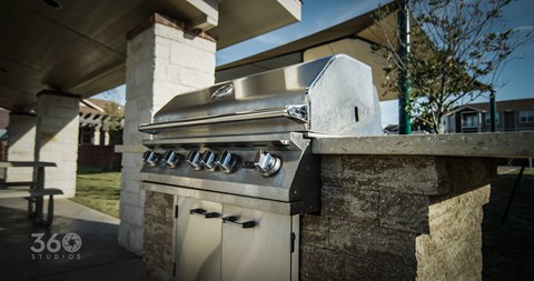 A modern outdoor kitchen with a built-in grill and sink.