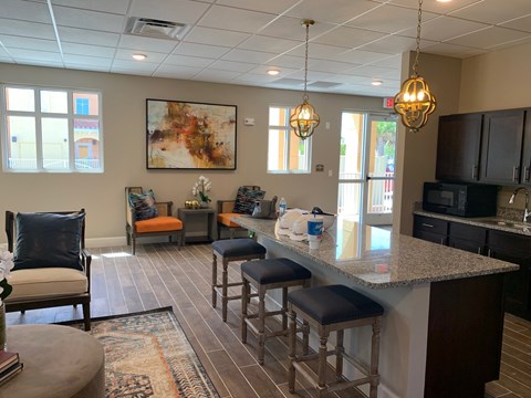 A kitchen with a bar and a painting on the wall.