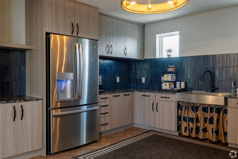 A modern kitchen with a stainless steel refrigerator and wooden cabinets.