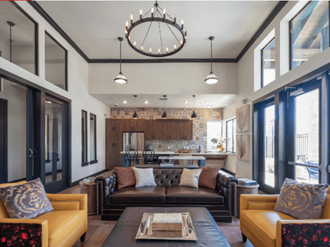 A modern living room with a brown leather couch and a chandelier.