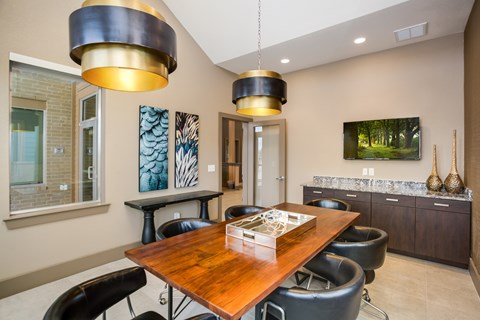 A modern dining room with a wooden table and black chairs.