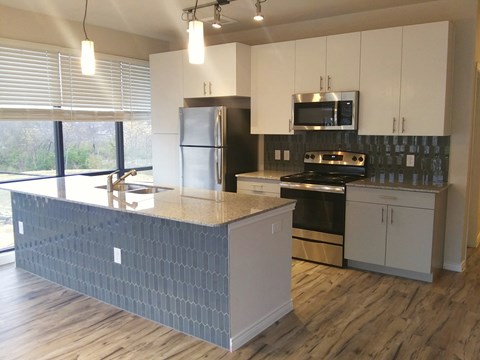 A kitchen with a stove top oven and a microwave above it.