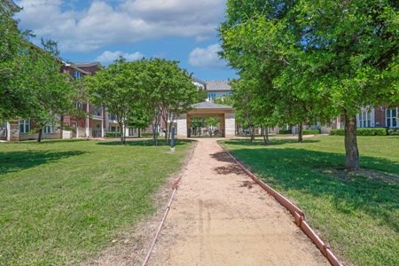 A pathway leads to a building in a park.